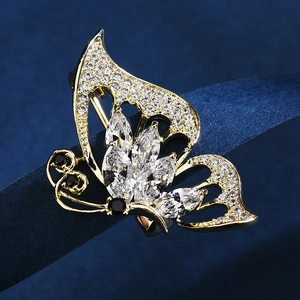 Broche papillon élégante en alliage doré avec zircons clairs sur fond bleu profond