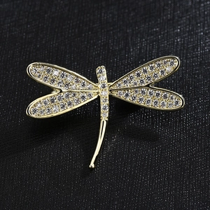 Exquisite goldene Libellen-Brosche mit weißen Zirkonia-Kristallen auf schwarzem Leder
