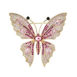 Elegant butterfly brooch with pink zircon stones and sparkling crystals on gold metal