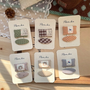 Handmade fabric polka dot hair clips set for kids with floral patterns on wooden tray