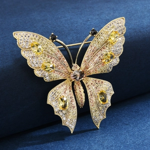 Elegant gold butterfly brooch with multicolored zircons on a navy velvet background