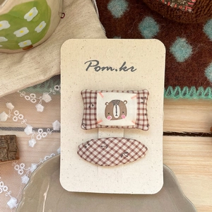 Detail of Korean style brown checkered hair clips with cute bear pattern on display card