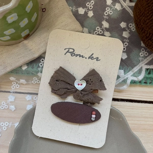 Détail d'un lot de barrettes à cheveux en dentelle marron et tissu élégant