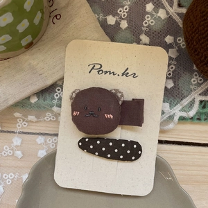 Détail de deux pinces à cheveux faites main en forme d'ours et à pois pour filles