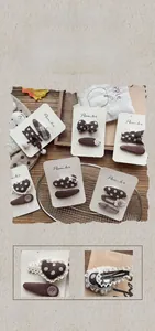 Close-up of handmade brown fabric hair clips with polka dots and vintage patterns