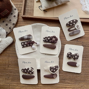 6-piece brown retro polka dot and plaid hair clips set for girls on display tray