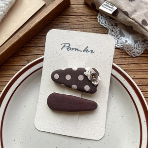 Detail of coffee-colored polka dot lace hair clips and solid retro clips for kids