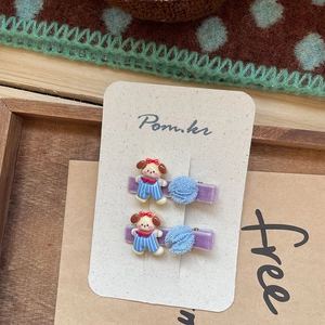 Detalle de horquillas de perrito con base de terciopelo morado y pompones de malla