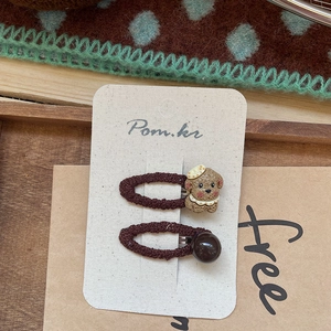 Détail de barrettes à cheveux en tricot marron avec chiot de dessin animé et perles décoratives