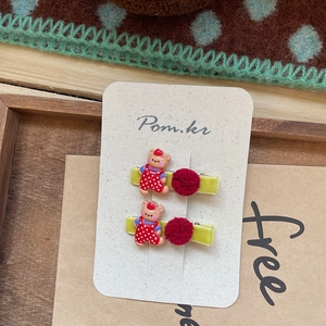 Detalle de pinzas para el pelo con pompones, motivo de oso y suave textura de terciopelo
