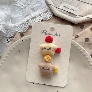 Detail von Plüsch-Stern-Haarspangen mit Pompons und Smiley-Gesicht auf koreanischem Stoff