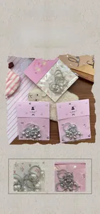 Close-up of silver heart pendant hair ties featuring fabric bands and metallic finish