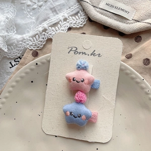 Nahaufnahme der Stern-Plüsch-Haarspangen mit Stickgesicht in Rosa und Hellblau