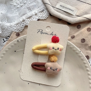 Nahaufnahme von Sternen-Plüsch-Haarspangen mit Smileys und bunten Pompons auf Karte