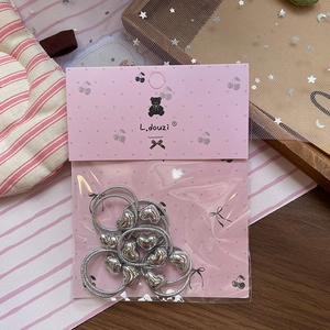 Detail of silver glitter hair ties with heart charms in sweet pink branded packaging