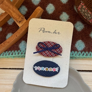 Détail de barrettes à cheveux faites main avec dentelle bleue et perles sur présentoir