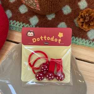Détail d'un ensemble d'accessoires de cheveux rouges à pois avec pinces et élastiques