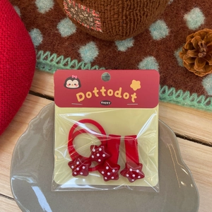 Détail du lot de barrettes étoiles rouges à pois blancs présentées sur un plat en céramique