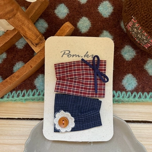 Détail de barrettes à carreaux faites main avec fleurs au crochet et nœuds sur carte