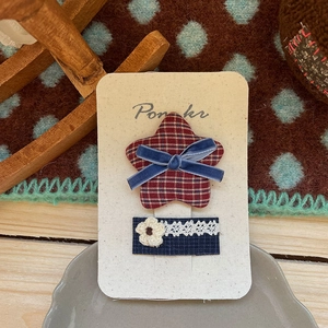 Détail de pince à cheveux faite main avec motif à carreaux et dentelle sur carton