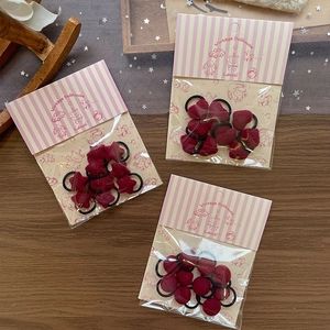 Set of 3 sweet red plush hair ties with heart and star shapes on vintage wood background