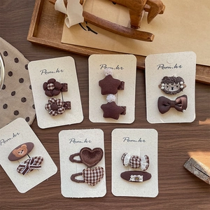 Vintage brown fabric hair clips set for girls featuring stars and bears on cardboard