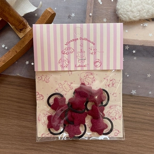 Set of 10 red plush star hair ties on vintage dollhouse card packaging with black elastic