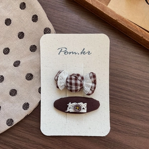 Detail of vintage handmade brown fabric hair clips with lace and button decorations