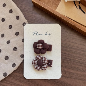 Detail of Korean style brown fabric flower hair clips set on vintage wooden display