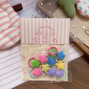 Nahaufnahme von bunten Plüsch-Stern-Haargummis für Kinder in Macaron-Farben