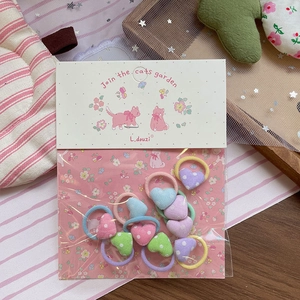 Set aus zehn bunten herzförmigen Stoff-Haargummis für Kinder in sanften Pastelltönen