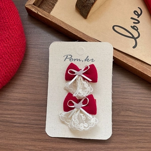 Gros plan de pinces à cheveux en tissu rouge avec dentelle blanche et motifs de cœur