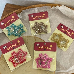 Set of five plush star-shaped hair clips in assorted colors on a minimalist display