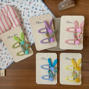 Floral bunny ear hair clips set for girls in five vibrant colors on wooden background