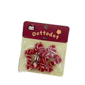 Pair of red plush star hair clips with striped accents in Dottodot brand packaging