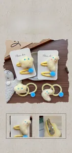 Détail du lot de barrettes en peluche jaune étoile et lune avec pompons bleus