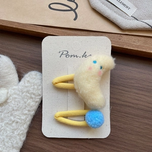 Détail de barrettes à cheveux en peluche avec lune et pompon sur emballage carte