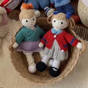 Handmade crochet wool dolls in a woven basket featuring intricate knitted outfits