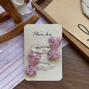 Détail de pinces à cheveux ours en paillettes roses avec dentelle sur bois