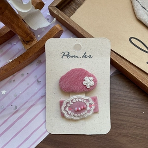 Détail de barrettes à cheveux en velours rose et dentelle avec perles sur carte