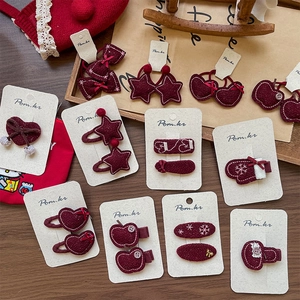 Red felt star and heart hair clips set for girls on a vintage festive winter background