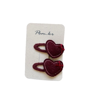 Pair of sweet red heart hair clips with glitter finish and bow on white card