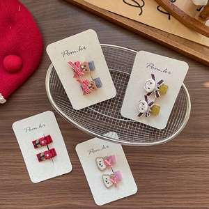Set of four Korean style fabric bear and floral hair clips for girls on a card