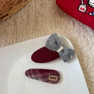 Détail d'une pince à cheveux à nœud rouge avec étiquette en cuir Baby de style coréen