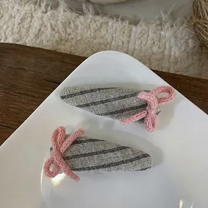 Détail de pinces à cheveux en tissu avec nœuds roses tricotés sur plat céramique
