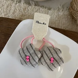 Détail de chouchous en forme d'étoile avec rayures grises et accents de perles roses