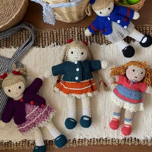 Set of four handmade crochet dolls in colorful outfits and varied hairstyles on a mat