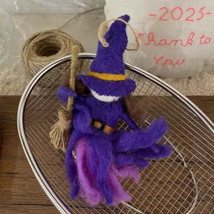 Detailed macro shot of a handmade purple felt witch pendant with a wooden broomstick accessory