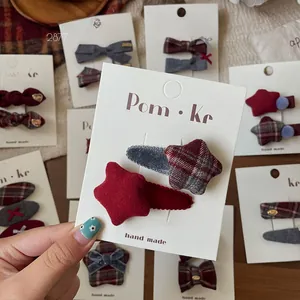 Detail of handmade plaid star hair clips in deep red and grey for girls