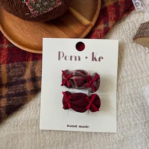 Detail view of handmade candy-shaped plaid hair clips on white display card